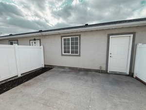 View of the patio and garage from patio door. Garden area to the left.