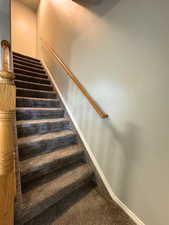Stairway featuring baseboards and carpet flooring