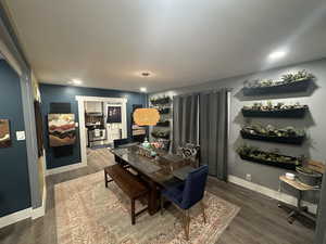 Dining area with dark wood-type flooring and recessed lighting