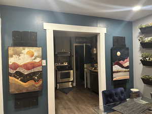 Kitchen featuring stainless steel range, dishwashing machine, dark wood-type flooring, and under cabinet range hood