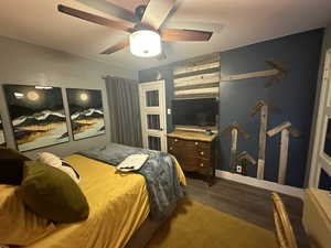 Bedroom featuring ceiling fan and dark wood-type flooring