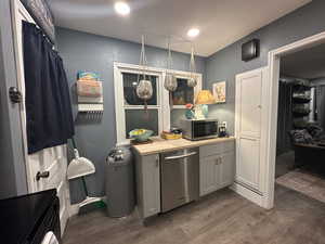 Kitchen with appliances with stainless steel finishes, wooden counters, gray cabinetry, dark wood-style floors, and recessed lighting