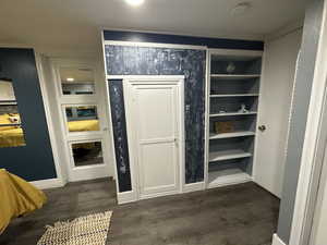 Interior space featuring built in features and dark wood-type flooring