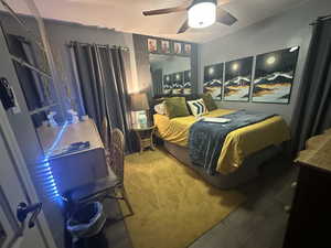 Carpeted bedroom featuring ceiling fan
