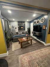 Living area with recessed lighting and dark wood-type flooring
