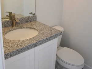 Half bathroom with vanity and toilet