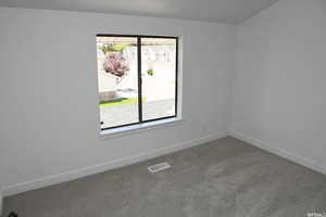 Carpeted empty room featuring baseboards