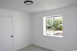 Spare room with baseboards and light colored carpet