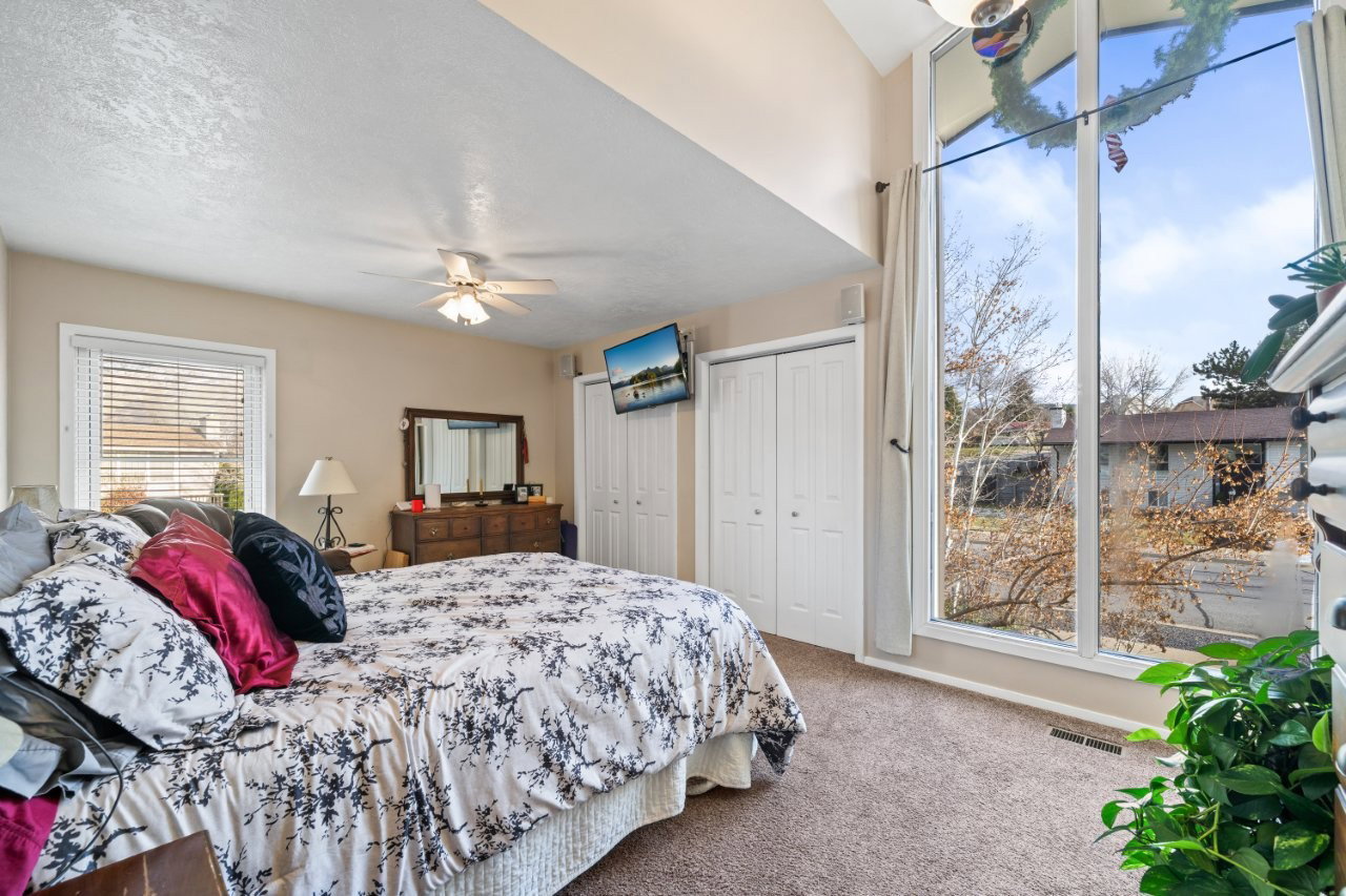 Bedroom featuring multiple closets, carpet flooring, and a ceiling fan