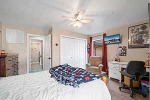Bedroom with a closet, a ceiling fan, and a desk