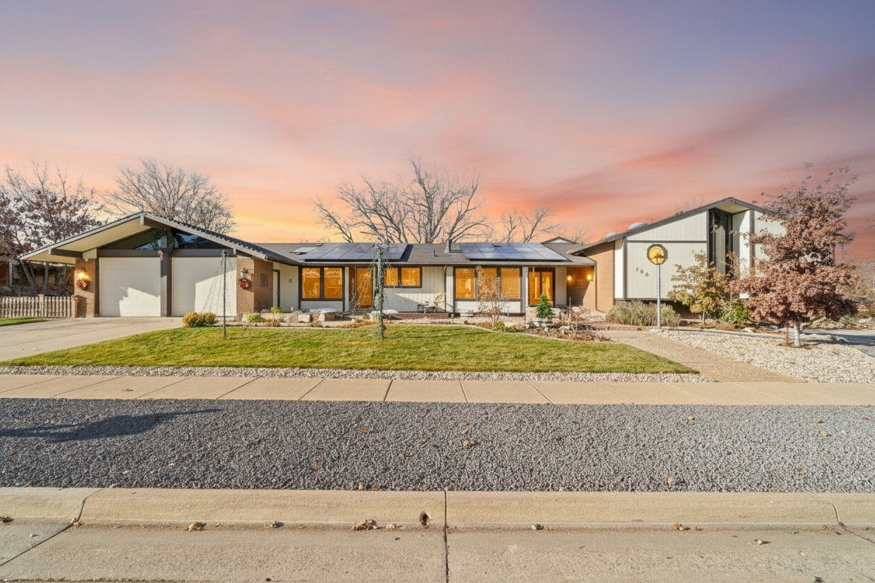 Single-story residence featuring a two-car garage with overhead doors, a paved driveway, and a front lawn