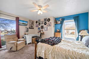 Bedroom with a ceiling fan and dark carpet