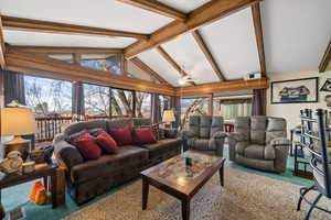 Carpeted living area with ceiling fan