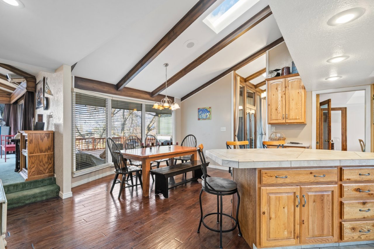 Kitchen featuring a kitchen breakfast bar, dark wood-style floors, a chandelier, pendant lighting, and tile countertops