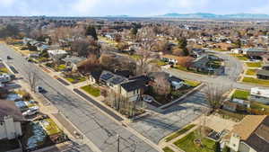 Aerial view of property and surrounding area with nearby suburban area and a mountain backdrop