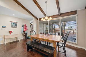 Dining area with dark wood finished floors and a chandelier