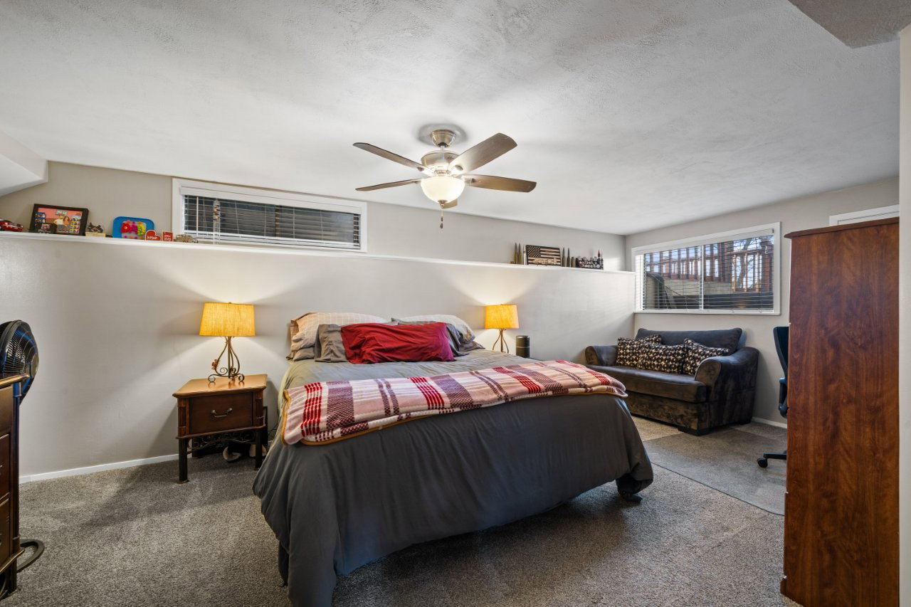 Carpeted bedroom featuring ceiling fan and baseboards