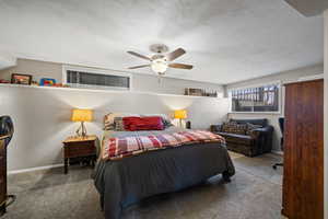 Carpeted bedroom featuring ceiling fan and baseboards
