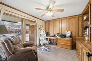 Office with ornamental molding, light carpet, and ceiling fan