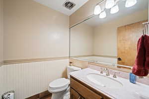 Half bath featuring vanity and wainscoting