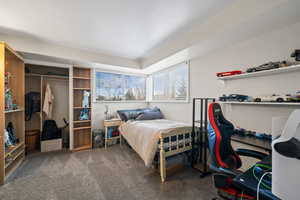 Bedroom featuring dark colored carpet and a closet