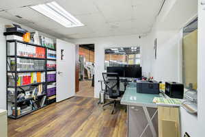 Office space featuring dark wood-style flooring and a drop ceiling