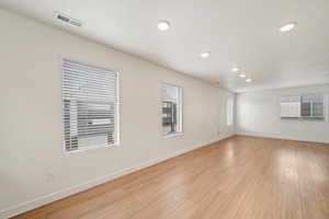 Empty room with light wood-type flooring and recessed lighting