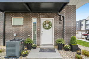 Property entrance featuring brick siding and covered porch