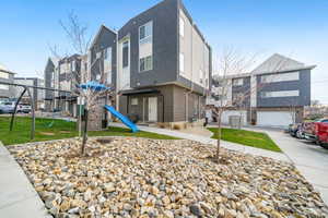 Contemporary home with stucco siding, brick siding, a front yard, and a residential view