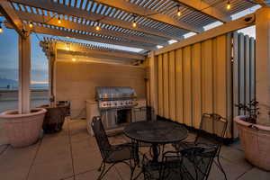 View of patio with outdoor dining area, a pergola, and a grill