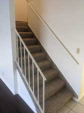 Stairway featuring baseboards and tile patterned floors