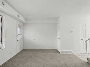 Living room featuring light colored carpet and a smoke detector