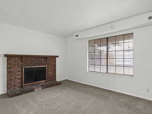Living room featuring carpet flooring and a brick fireplace