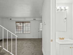 Staircase with a textured ceiling and carpet