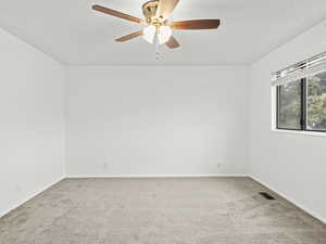 2nd bed room with light carpet and ceiling fan