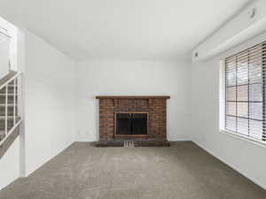 Living room featuring a brick fireplace and carpet floors