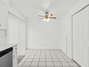 Kitchen featuring dishwasher, white cabinets, ceiling fan, light tile patterned flooring, and a textured ceiling