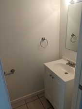 Bathroom with light tile patterned floors and vanity