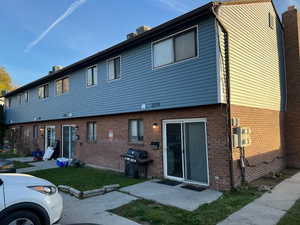 Rear view of house with brick siding and BRAND NEW vinyl siding, a yard, and a patio