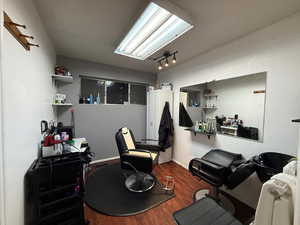 Miscellaneous room with dark wood-style floors, track lighting, and a desk