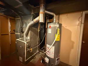 Utility room featuring water heater and heating unit