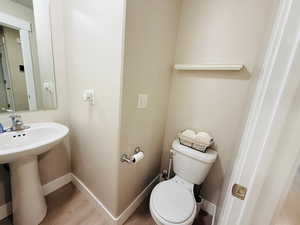 Half bathroom featuring wood finished floors and baseboards
