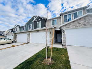 View of front of home with stone siding and concrete driveway