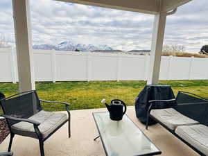 Fenced backyard featuring a patio area, a mountain view, and a grill