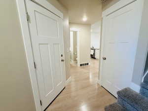 Corridor with light wood-style flooring and baseboards