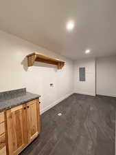 Basement laundry room with recessed lighting, cabinet space, washer hookup, and electric panel