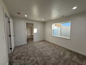 Bedroom 4 featuring a walk in closet, a textured ceiling, carpet, and recessed lighting