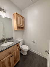Half Bathroom with vanity and wood tiled floors