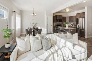 Living area with a chandelier and dark wood-style flooring
