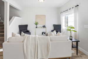 Living area featuring stairs and baseboards